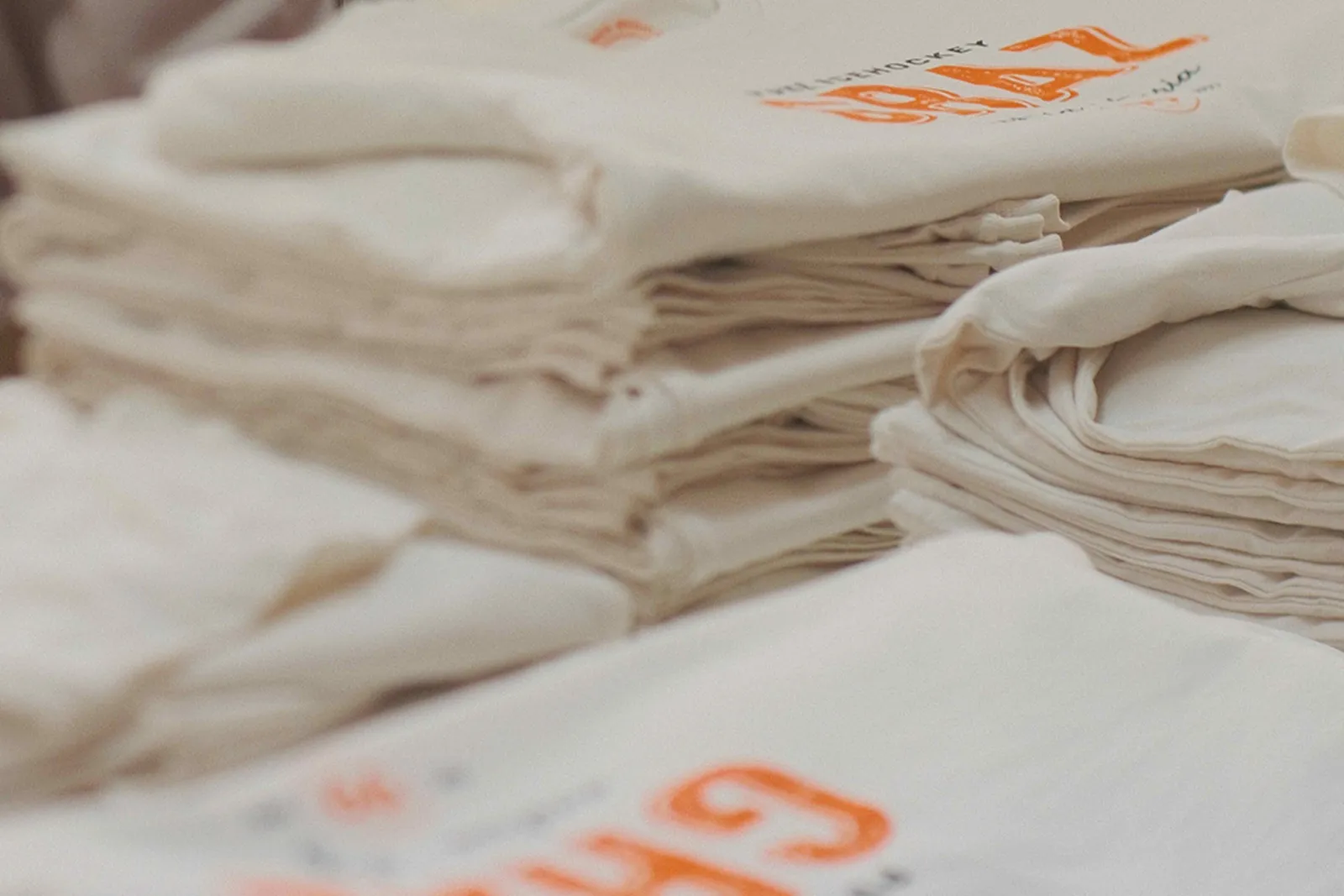 Graz 99ers Fan-Shirt in Off-White mit 2-farbigem Siebdruck — Schwarz und CI-Orange Pantone