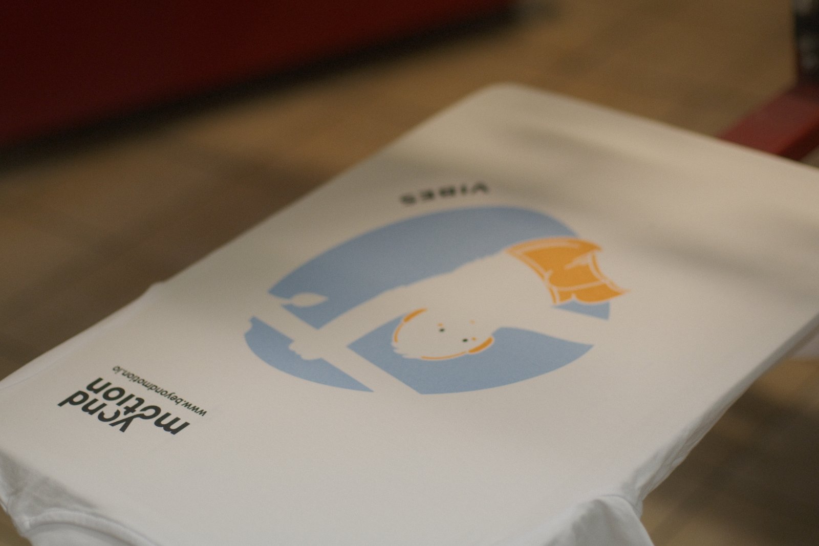 Gestapelte Beyond-Motion-Shirts — im Nacken das DTF-Label mit QR-Code und Logo sichtbar