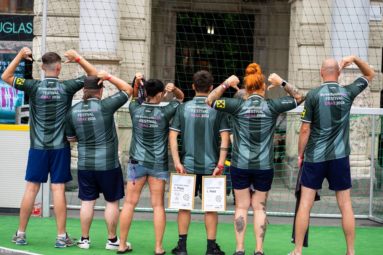 Spielerinnen und Spieler von hinten mit dem großen Backprint „streetfootbALL FESTIVAL GRAZ 2026