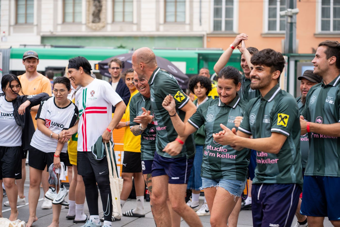Ausgelassene Siegesfeier auf dem Grazer Hauptplatz, Team in streetfootbALL-Trikots mit Aus'm-Keller-Sponsorprint