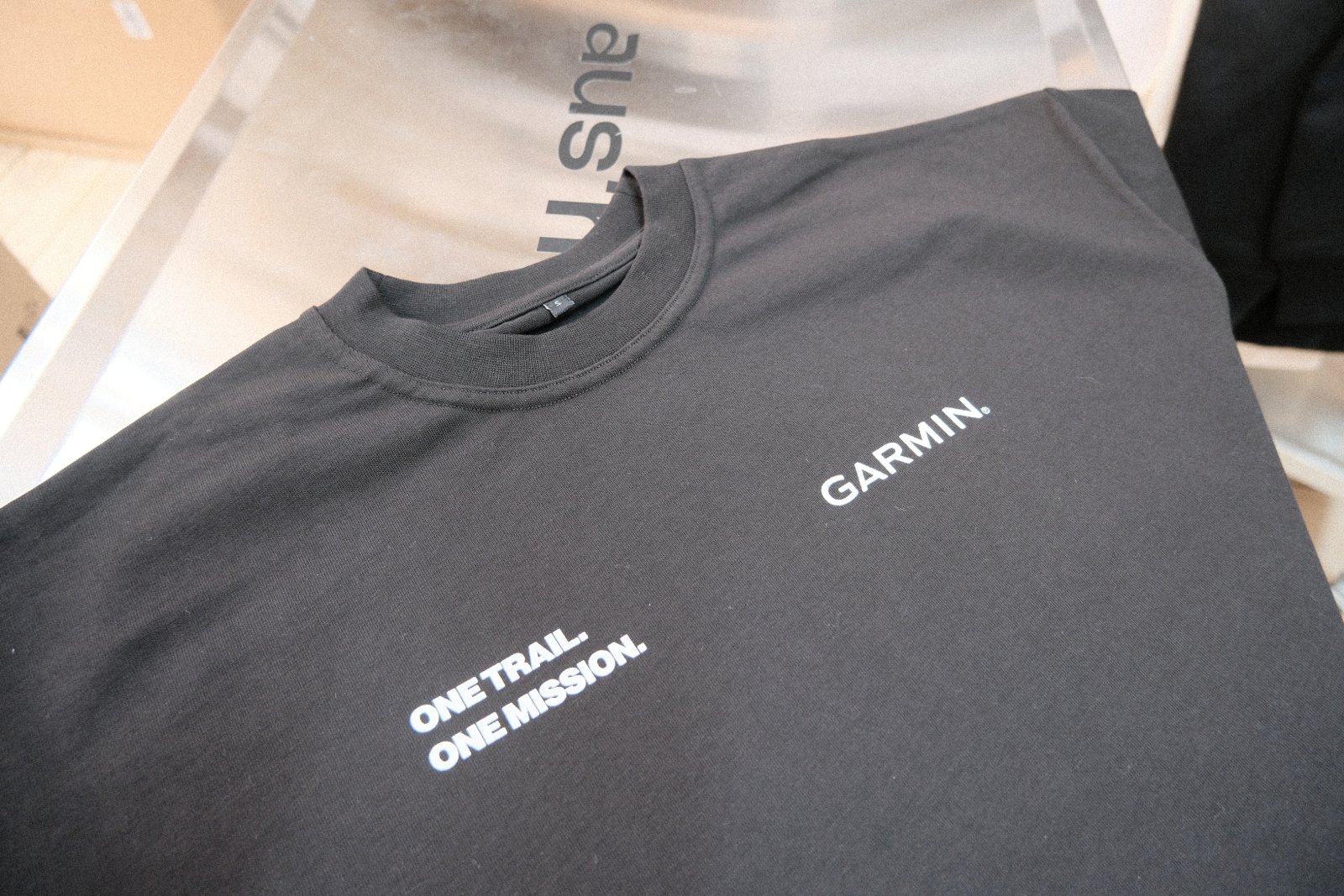 Frontprint-Detail des Heavy-Oversized-Shirts — Garmin-Logo und Claim „one trail. one mission.