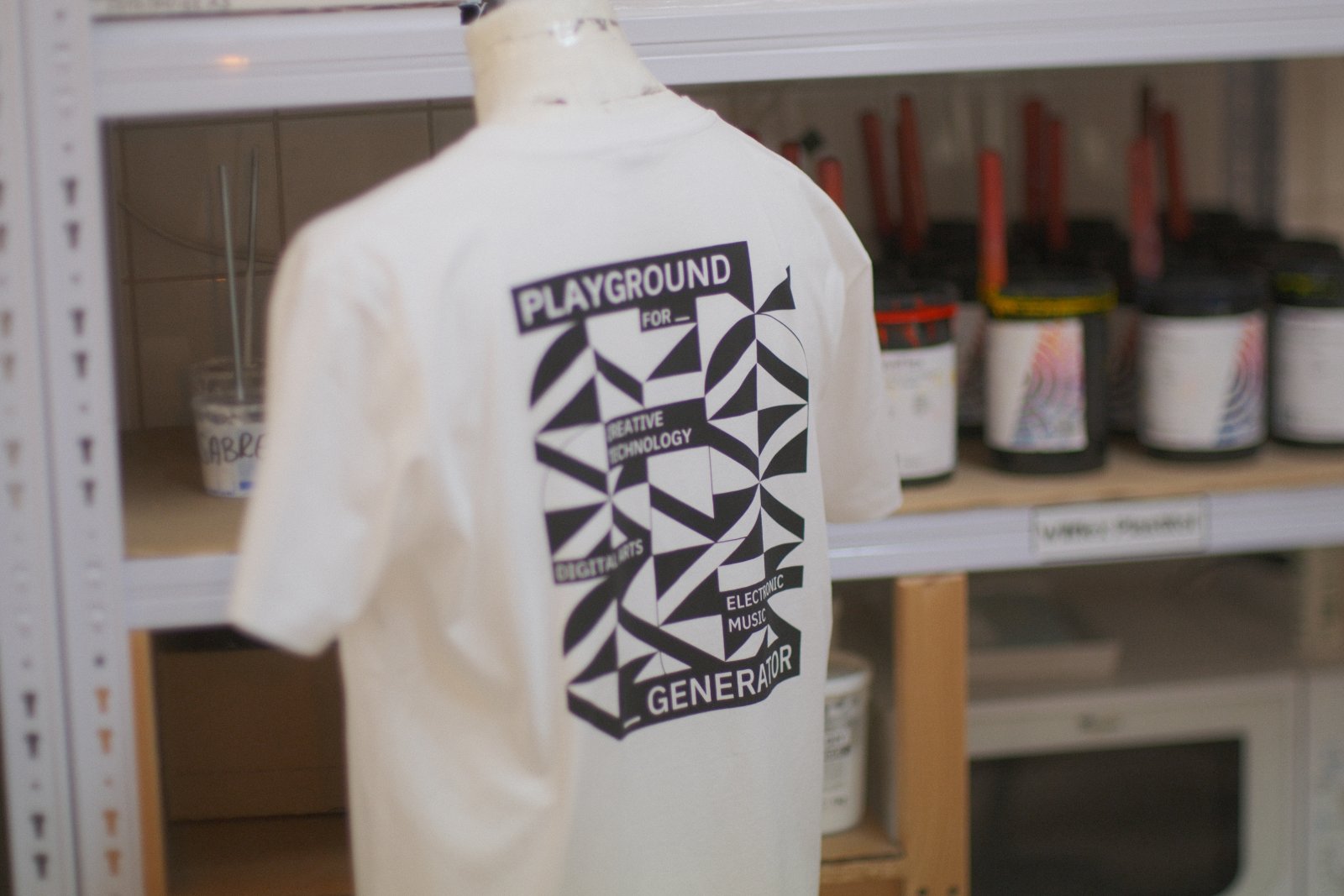 Naturweißes Generate26-Festival-Shirt auf der Schneiderpuppe mit großem Backprint im Algae-Ink-Siebdruck — Motiv „Playground for Creative Technology, Digital Arts, Electronic Music