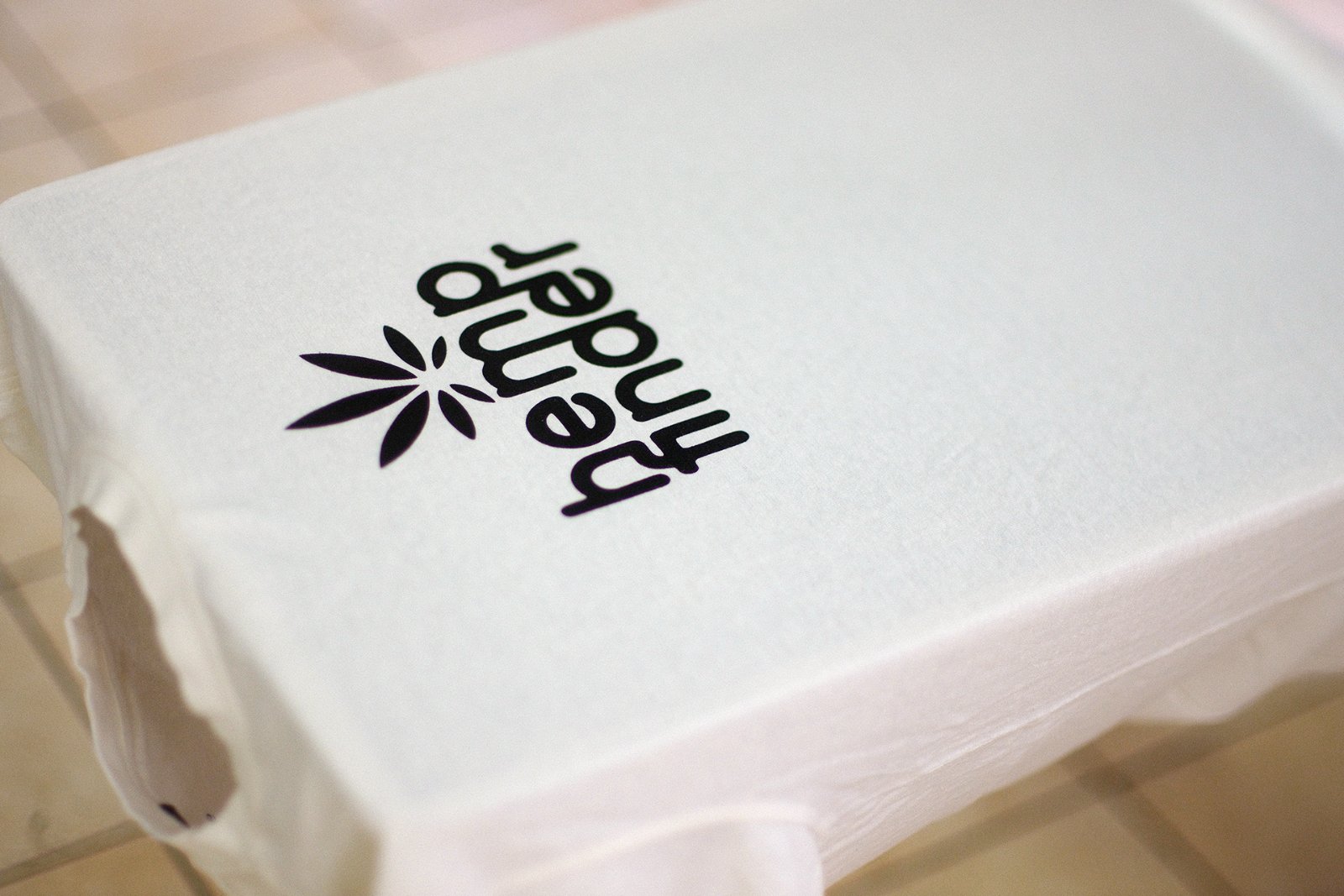 Bedrucktes Hanf-Shirt auf der Druckplatte mit dem fertigen hemp-finder-Print in schwarzer Algenfarbe
