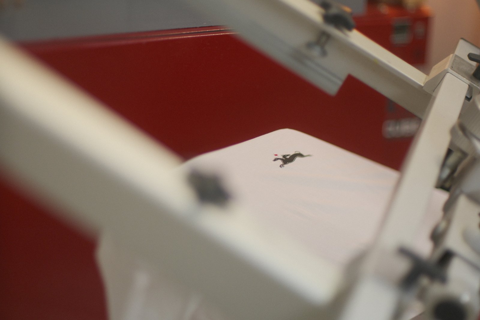 Siebdruck-Vorgang auf weißem Krawall-Bar-Shirt — kleines Pferd-mit-Star-Logo wird im Direktdruck aufgebracht