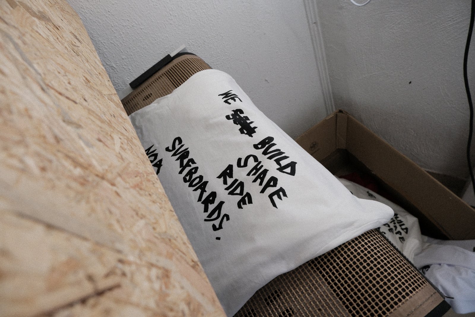 Fertig bedrucktes weißes NOA-Surfboards-Shirt mit dem handgeletterten Statement-Motiv