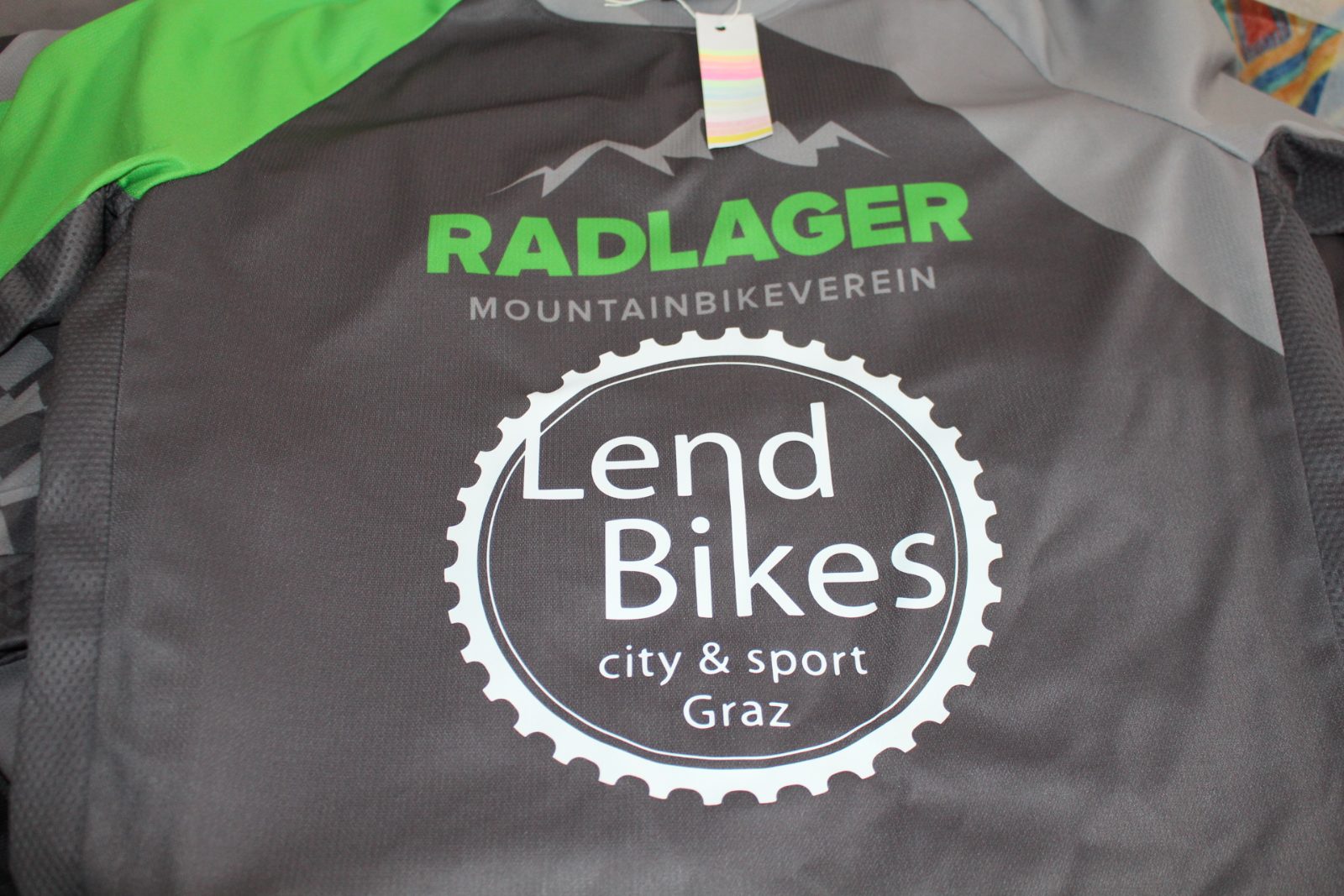 Entgittertes weißes Sport-Vinyl auf grüner Trägerfolie: spiegelverkehrtes Lend-Bikes-Logo, bereit zum Verpressen