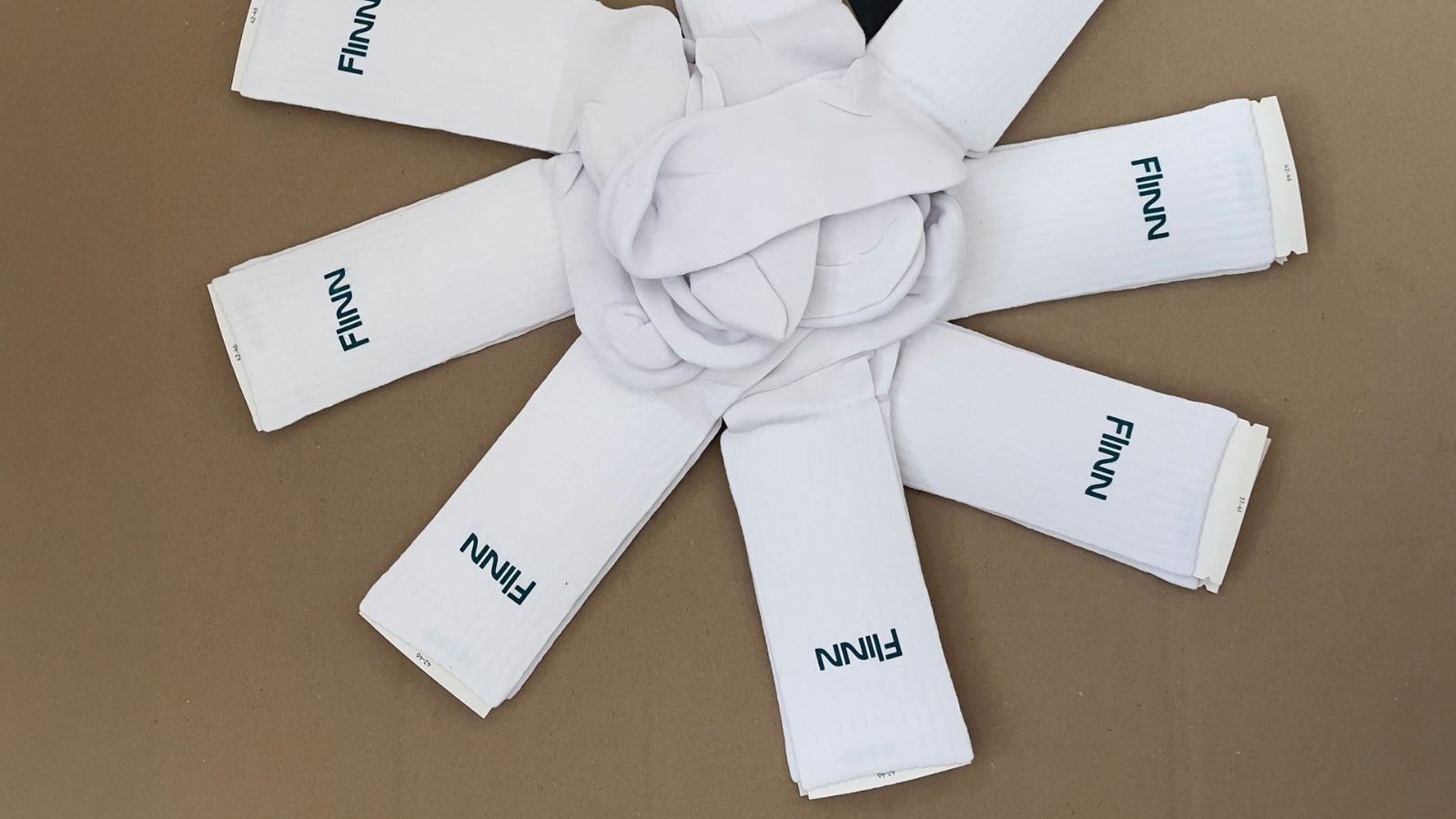Mehrere bedruckte FINN-Socken sternförmig aufgefächert, mit sichtbaren Größenetiketten 42–46 und 37–41