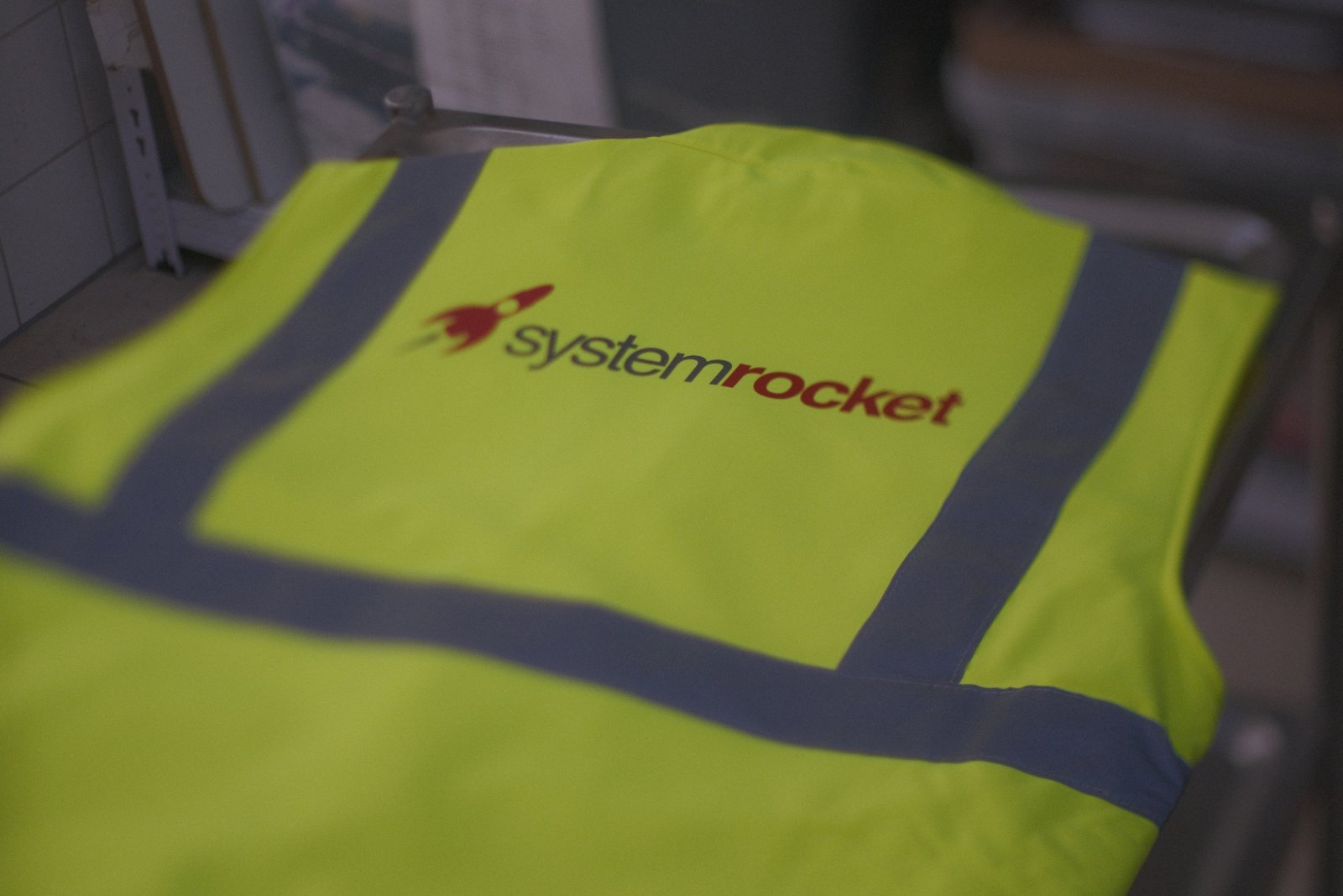 Detail der fertigen Systemrocket-Warnweste — sauber leuchtendes Logo dank Spezial-DTF mit Sperrschicht gegen Dye-Migration