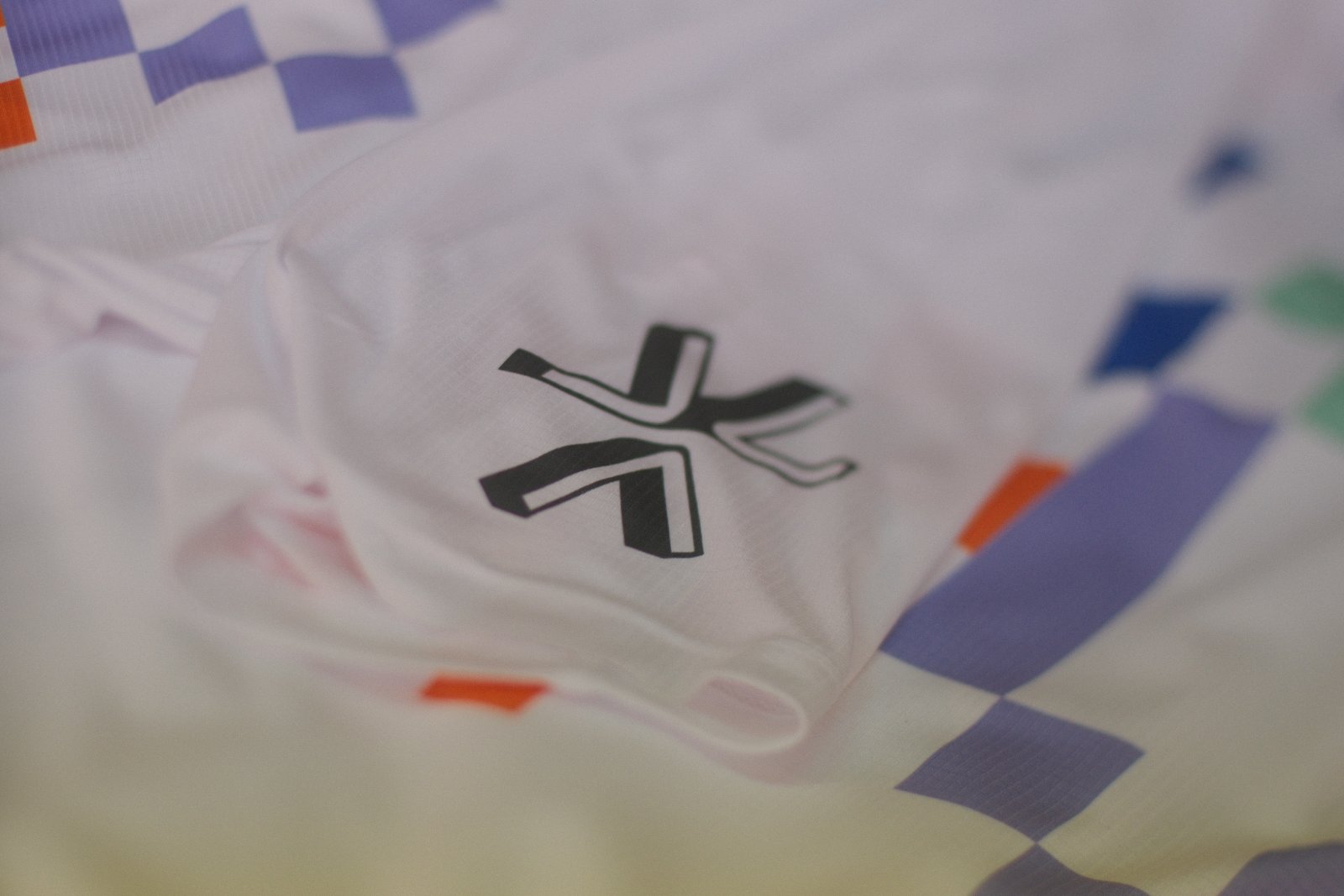 Schwarzer Stern-Akzent als Sublimationsdruck zwischen den farbigen Pixel-Pattern-Flächen des Webduett-Shirts